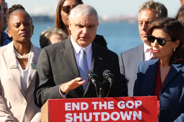 President Mario Cilento speaking at press conference at podium that says "end the GOP shutdown"